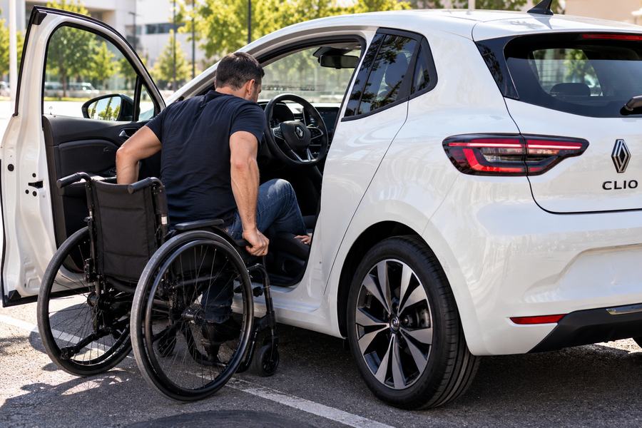 Wheelchair user getting into an adapted Renault Clio